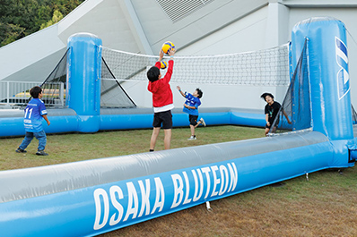 写真:バレーボールコートで遊ぶ子供たち