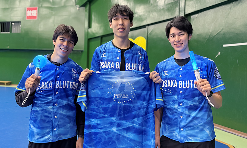写真：オリジナルユニフォームを持っているポン選手とオリジナルペンライトを持っているバグナス選手、甲斐選手